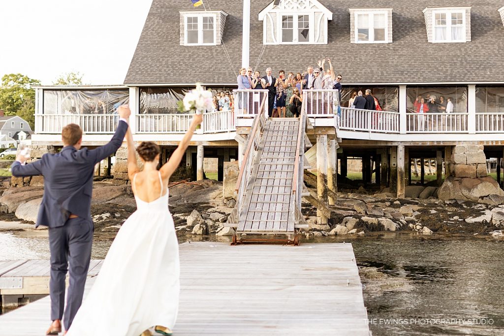 Guests greet the bride and groom as they exit the boat for their Annisquam Yacht Club wedding in Gloucester.