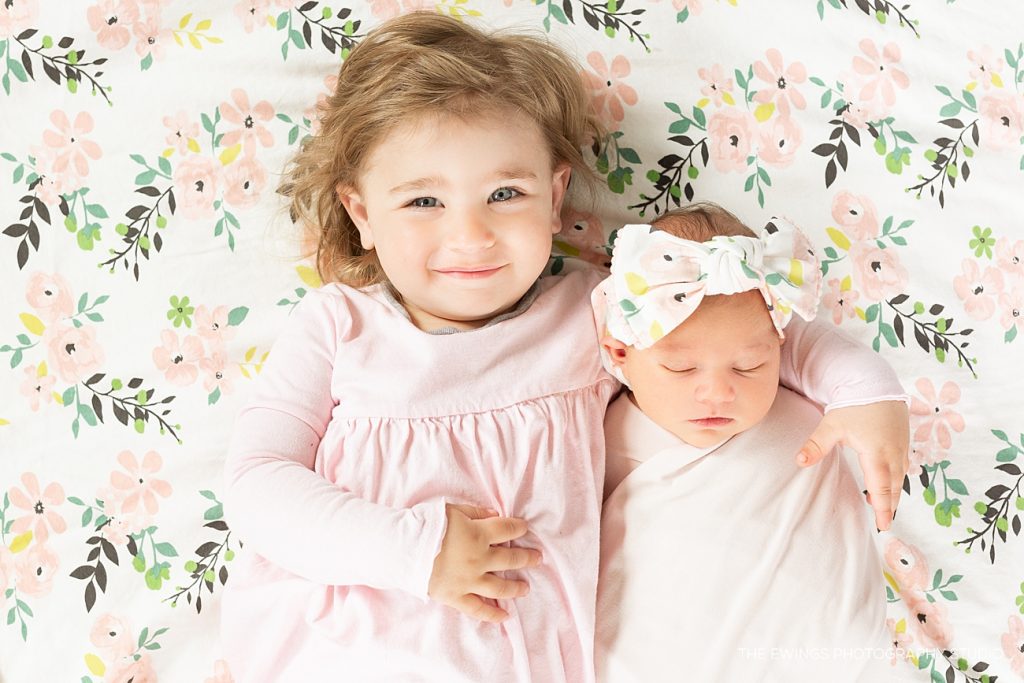 This is a newborn baby girl portrait with her big sister who is 2 years old.
