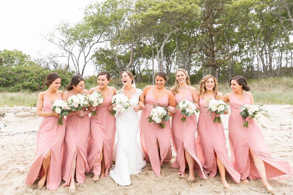 A bride and her bridesmaids portraits at the beach near Popponesset Inn, a beach wedding venue in Falmouth