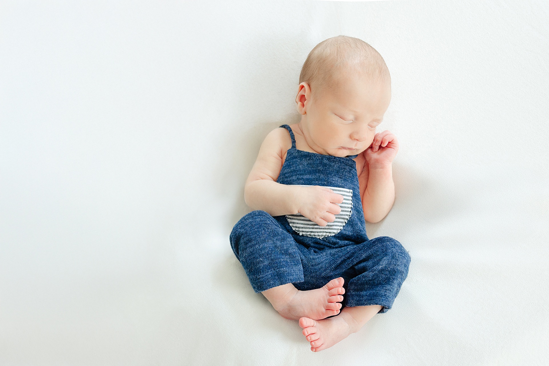 An in-home newborn session with Winchester MA Newborn Photographer, Erica Ewing, one of the best newborn photographers in the greater boston area. This is a posed newborn picture of baby alone.